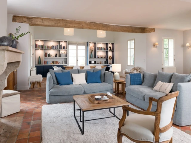 Salon rénové d'une maison de campagne française avec poutres et tomettes